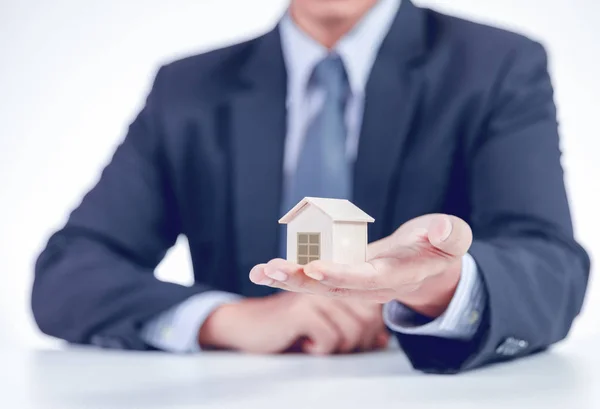Businessman showing home on hand — Stock Photo, Image
