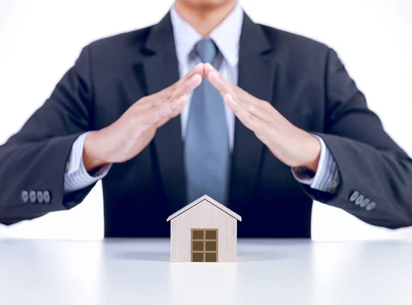 Businessman covering home with hands, insurance concept — Stock Photo, Image