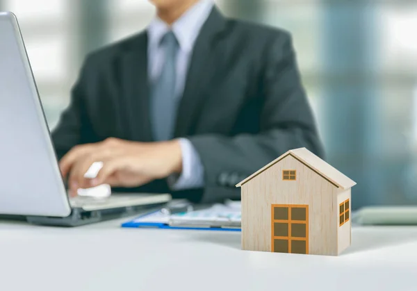 Бізнесмен пише бізнес-план з діаграмою і дерев'яною моделлю будинку — стокове фото