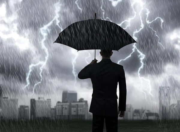 Επιχειρηματίας κρατήστε μαύρη ομπρέλα που στέκεται κάτω από βροχή καταιγίδα αστραπή με φόντο πόλη — Φωτογραφία Αρχείου