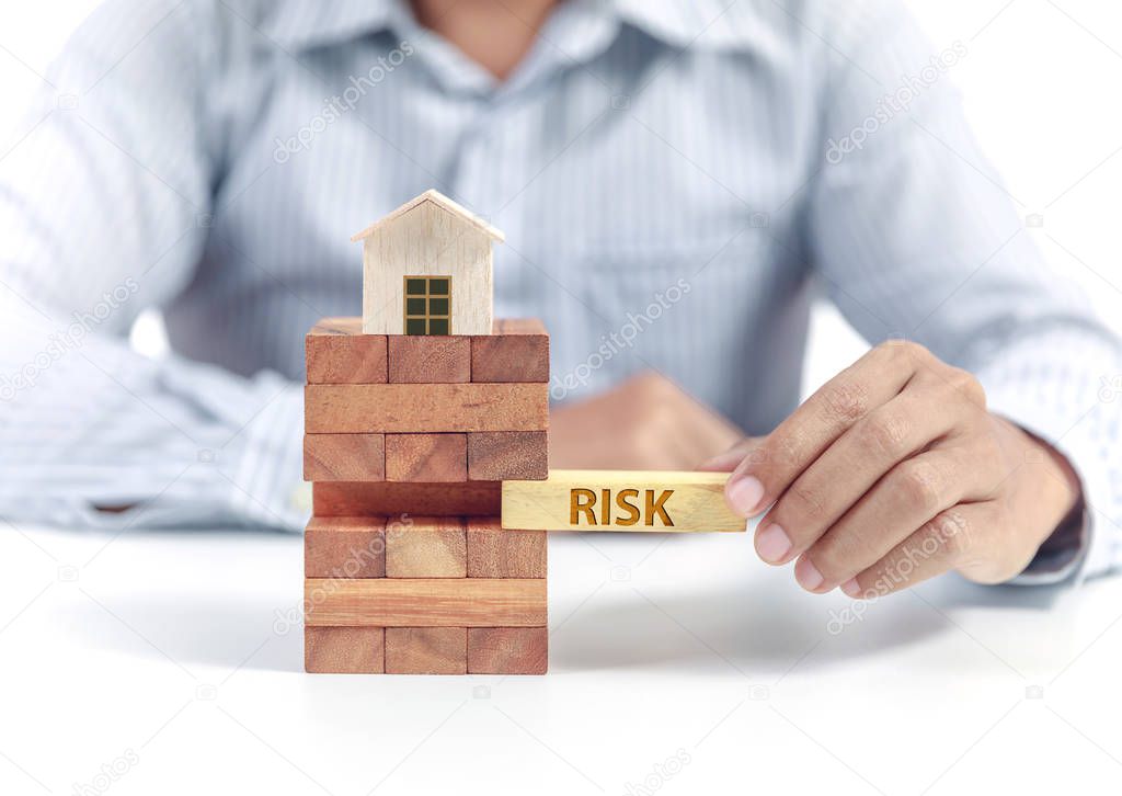 Businessman hold wooden bloc with wording risk, insurance concept