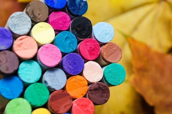 Різні кольорові пастельні чаші на фоні осіннього листя — стокове фото