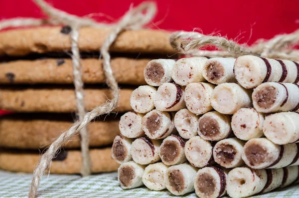 Stack of cookies and tubes connected with a rope — Stock Photo, Image