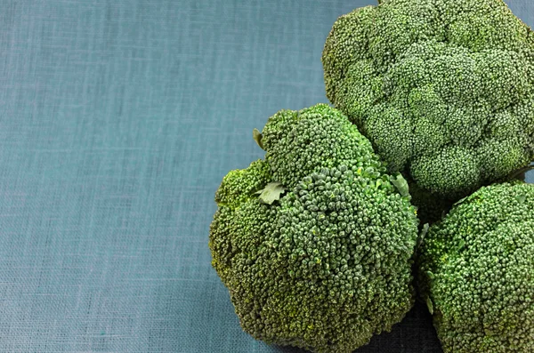 Brócoli verde sobre un fondo de tela, producto crudo —  Fotos de Stock