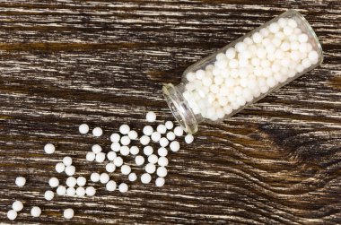 Homeopatik bezelye ahşap arka plan üzerinde dağınık. Alternatif Tıp kavramı