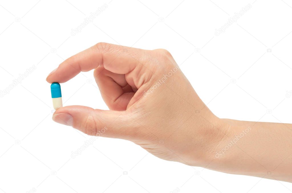 Beautiful female hand holds pill gesture. Isolated on white background