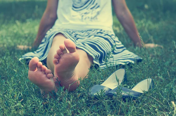緑の草の上に横たわるスカートの少女。残り、静けさおよび弛緩のコンセプト. — ストック写真