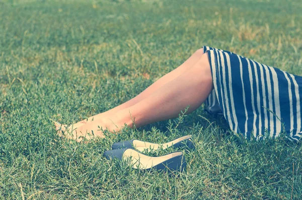 Fille en jupe couchée sur l'herbe verte. Le concept de repos, de tranquillité et de détente . — Photo