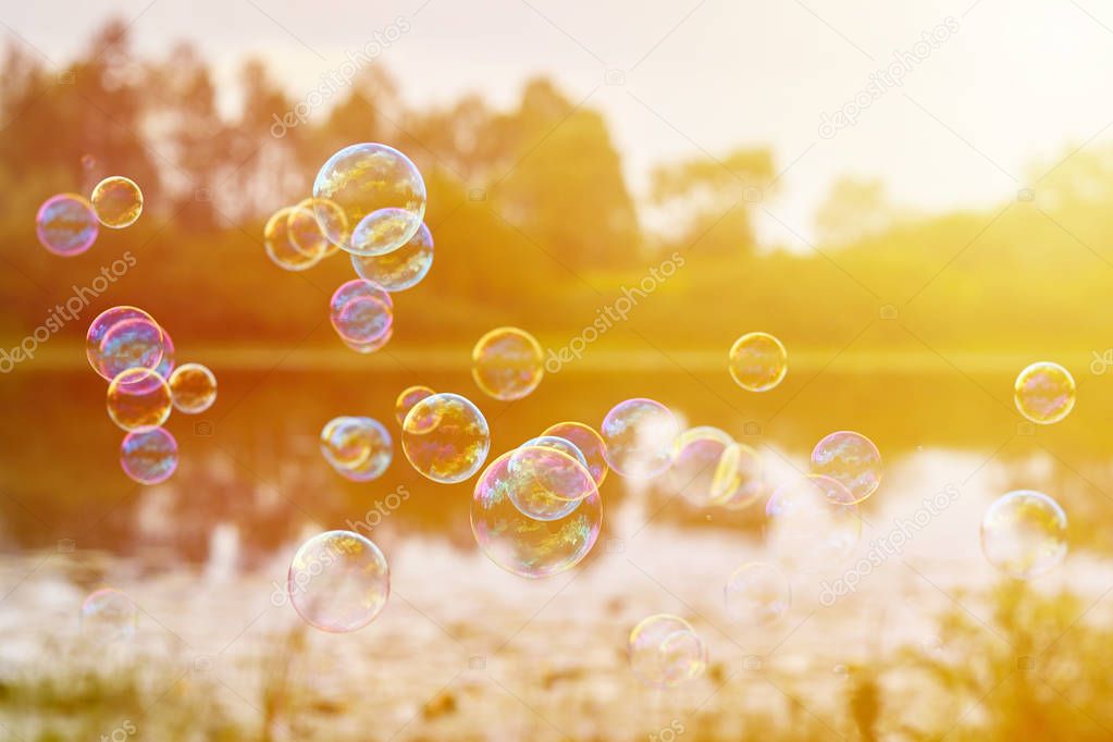 Soap bubbles on the banks of the River Fly downwind. The concept of lightness and airiness, sunlight