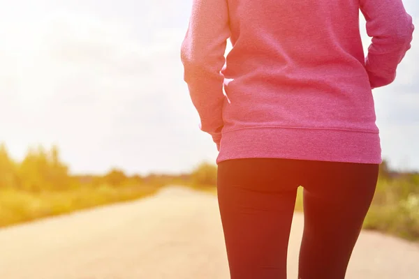 Fille en sweat à capuche rose pratique la course cardio dans les bois, image tonique — Photo