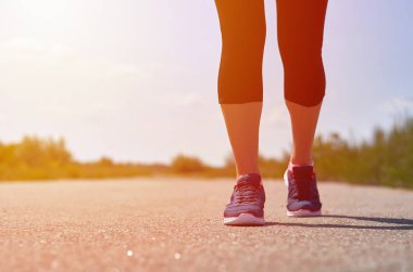 Kız yolda çalışır. Spor ayakkabılar bacaklar