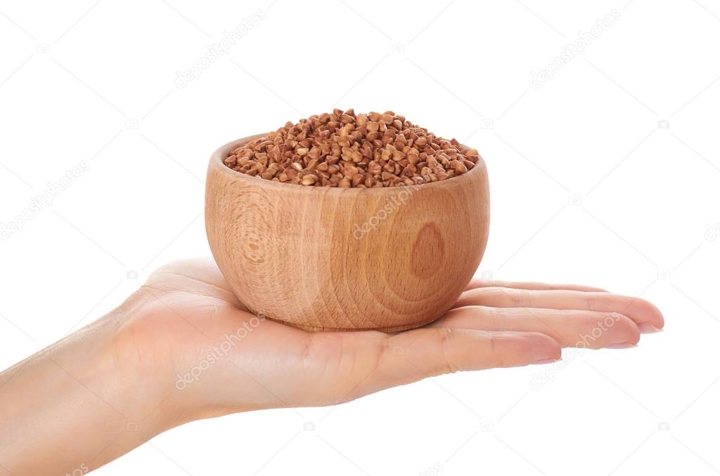 organic buckwheat in wooden pot in hand isolated on white background