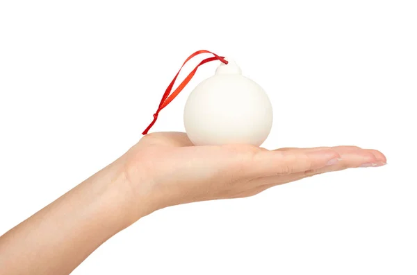 Decoración de Navidad, bola blanca de cerámica de vidrio en mano aislada sobre fondo blanco. Objeto de Año Nuevo — Foto de Stock