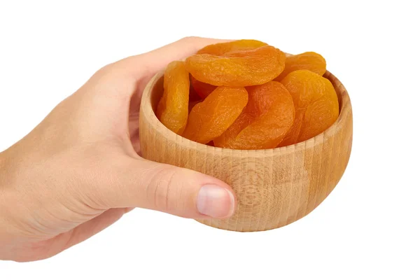 Delicious and healthy dried apricots in wooden bowl in hand isolated on white background, healthy sweet snack — Stock Photo, Image