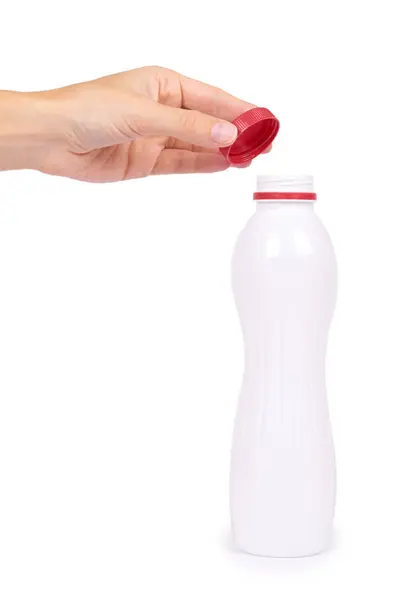 Bottiglia di yogurt con tappo rosso in mano isolato su sfondo bianco, stile di vita sano, contenitore di plastica per il latte — Foto Stock