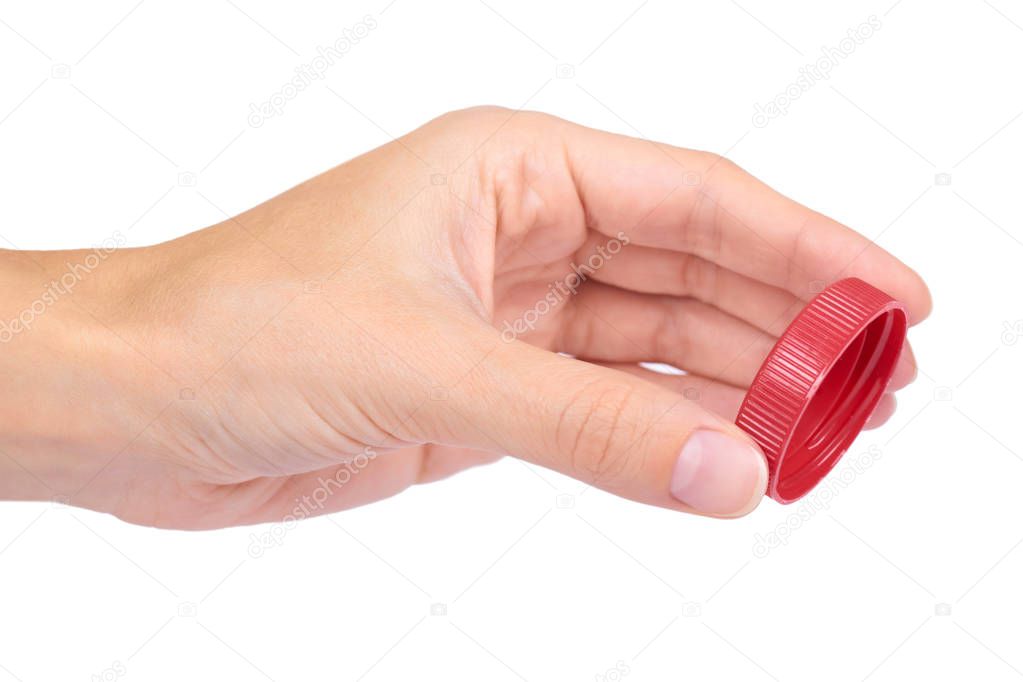 Single red plastic bottle cap in hand isolated on white background