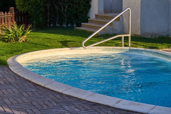 Piscina com escada de metal. Água azul — Fotografia de Stock