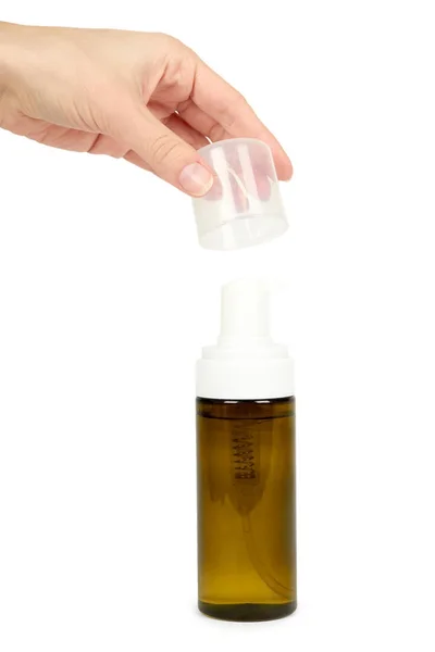 Flacone spray in plastica con pompa in mano isolato su fondo bianco. Distributore di schiuma per la cura del viso. Contenitore con lozione corpo . — Foto Stock