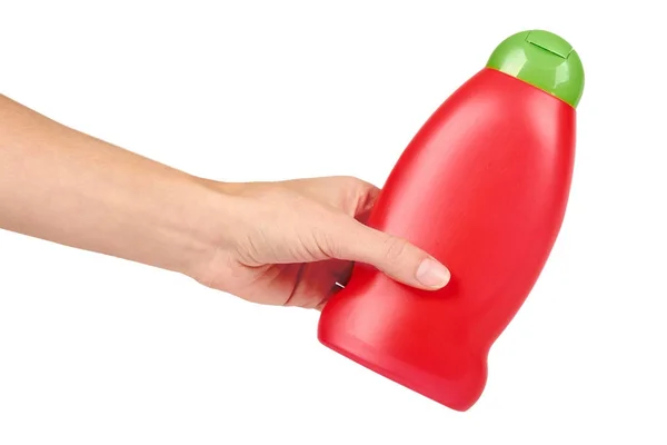 Röd plast flaska för schampo i handen isolerad på vit bakgrund. Hydiene och rengöring idé — Stockfoto