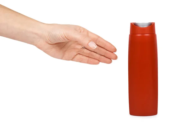Gel de chuveiro em garrafa de plástico vermelho na mão. Isolado sobre um fundo branco. Creme para cuidados com o corpo, sabão higiénico. Modelo em branco — Fotografia de Stock