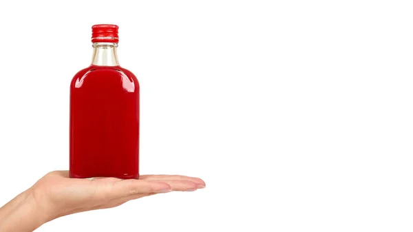 Glass bottle with red tincture in hand isolated on white background. Alcohol problem. copy space, template — Stock Photo, Image