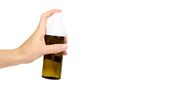 Kunststoff-Sprühflasche mit Pumpe in der Hand isoliert auf weißem Hintergrund. Schaumspender für die Gesichtspflege. Behälter mit Körperlotion. Kopierraum, Vorlage. — Stockfoto