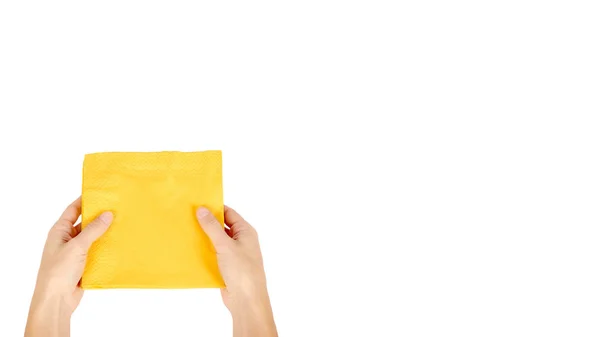 Yellow paper napkin for food in hand isolated on white background. Kitchen serving object. copy space, template — Stock Photo, Image