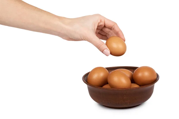 Huevos orgánicos de pollo marrón en tazón de barro en mano. Aislado sobre fondo blanco. Reserva nutritiva y proteica — Foto de Stock