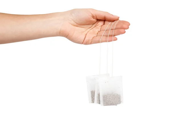 Tea in paper bag in hand. Isolated on white background. Herbal teabag — Stock Photo, Image