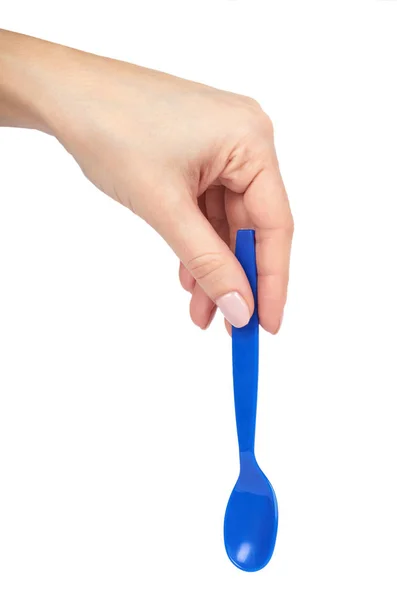 Cucchiaino di plastica blu con mano. Isolato su sfondo bianco. Utensile per bambini — Foto Stock