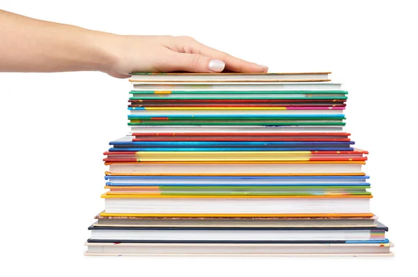 Diferentes livros coloridos em pilha com a mão isolada no fundo branco — Fotografia de Stock