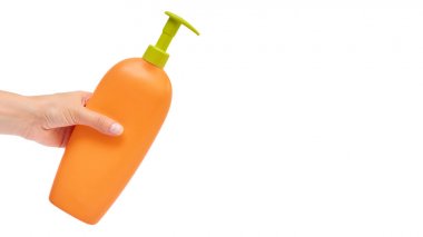 Beyaz arka plan üzerinde izole şampuan şişesi tutan el. kopyalama alanı şablonu