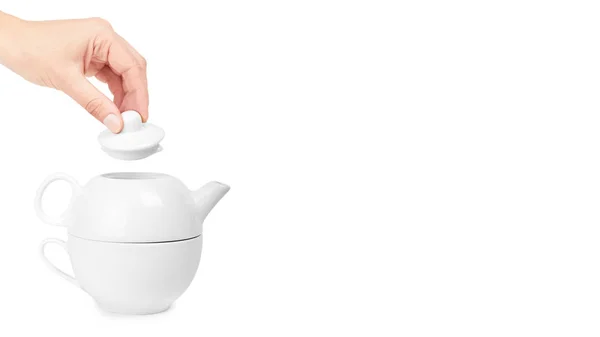 White ceramic kettle or teapot with cup in hand. Isolated on white background. copy space, template — Stock Photo, Image