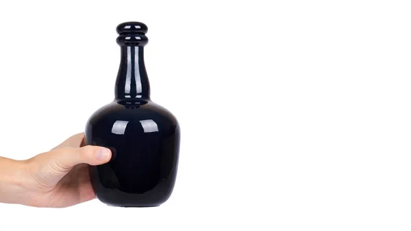 Mooie zwarte fles in hand geïsoleerd op een witte achtergrond, dure alcohol, luxe drankje. kopiëren van ruimte, sjabloon — Stockfoto