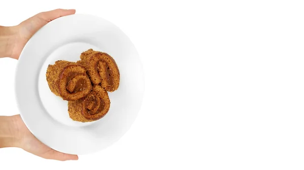 Köstliche Schokolade mit Milch Schweizer Rollkuchen in der Hand auf Teller isoliert auf weißem Hintergrund, hausgemachtes Dessert. Kopierraum, Vorlage — Stockfoto