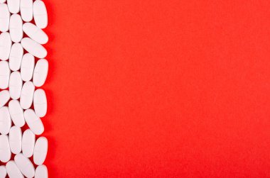 Kırmızı arka planda beyaz ilaç bileşimi.