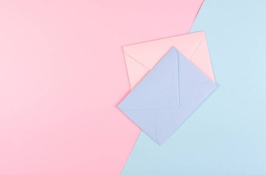 Blue paper envelope composition on pink background. clipart