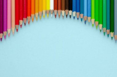 Mavi arka planda renkli kalemler kompozisyonu. Düz yatıyordu.