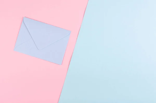 Komposition aus blauem Papierumschlag auf rosa Hintergrund. — Stockfoto