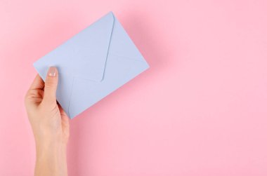 Pembe arka planda mavi kağıt zarf kompozisyonu.