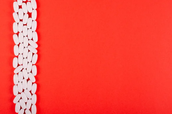 Blanc composition des pilules médicales sur fond rouge . — Photo