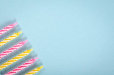 Mavi arkaplanda renkli mumlar, parti ve kutlama dekorasyonu.