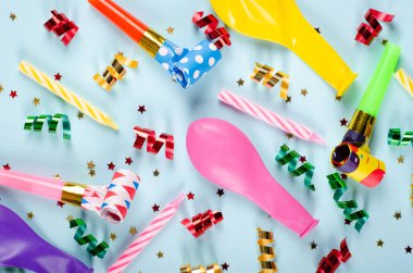 Mavi arka planda renkli konfeti ve hava balonları kompozisyonu, parti ve kutlama dekorasyonu.