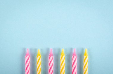 Mavi arkaplanda renkli mumlar, parti ve kutlama dekorasyonu.