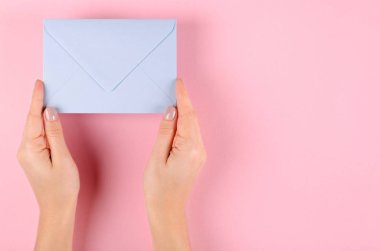 Pembe arka planda mavi kağıt zarf kompozisyonu.
