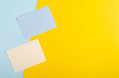 Mavi arka planda kağıt zarf kompozisyonu. Düz yatıyordu.