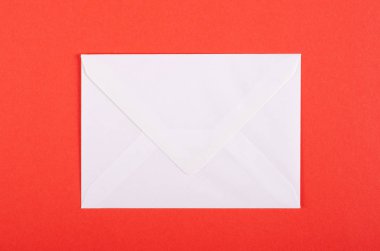 Kırmızı arka planda kağıt zarf kompozisyonu. Düz yatıyordu.