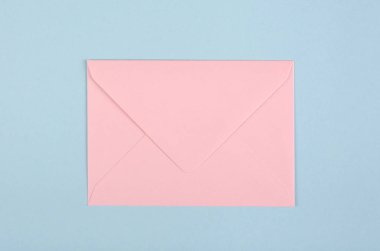 Mavi arkaplanda pembe kağıt zarf kompozisyonu.
