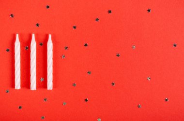 Kırmızı zemin, parti ve kutlama dekorasyonu üzerine beyaz mumlar..