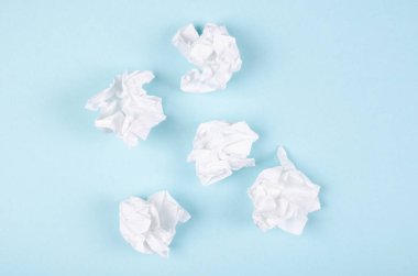 Mavi arka planda buruşmuş kağıt kompozisyonu. Düz yatıyordu.